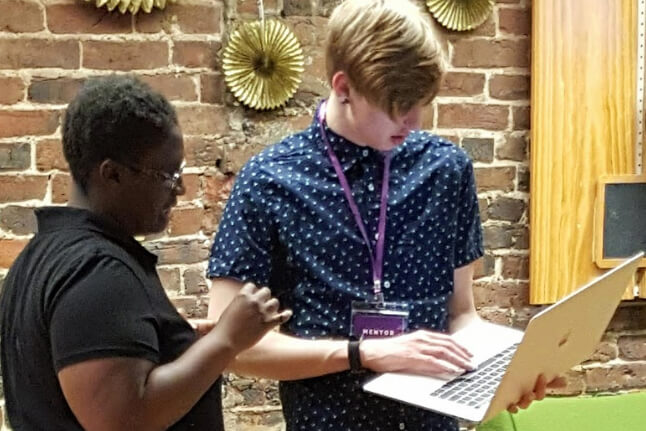 Attendee examining laptop with mentor